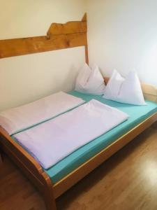 a bed with white sheets and pillows on it at OMLADINSKI HOTEL ROSTOVO in Bugojno