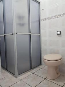 a bathroom with a toilet and a shower stall at Casa de praia in Guaratuba +18 photos