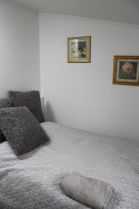 een slaapkamer met een bed met twee foto's aan de muur bij Bullseye Kristiansand in Kristiansand
