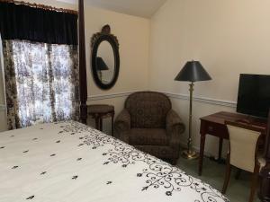 a bedroom with a bed and a chair and a mirror at The Inn at Benicia Bay in Benicia