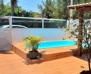 a backyard with a swimming pool and a wooden deck at CASA DE PRAIA - Verão Vermelho I - Cabo Frio - Unamar in Cabo Frio