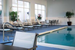a pool in a building with chairs and tables at Best Western Plus Waynesboro in Waynesboro