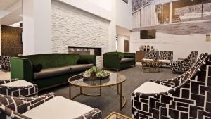 a lobby with a couch and chairs and a fireplace at Best Western Plus Morden in Morden