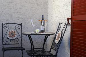 uma mesa com duas cadeiras e uma garrafa de vinho em Garni Villa Betty em Merano