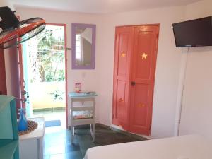 Habitación con puerta roja y TV. en Casa Delfin Guest House, en Las Terrenas