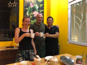 a group of people holding coffee mugs at a table at Restfull apartment-14 Mai Thuc Lan, My An , Da nang in Danang