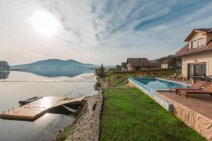 a house with a swimming pool next to a lake at Villa Sablja-with pool in Ogulin