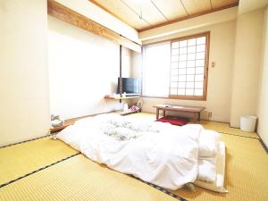 Un pat sau paturi într-o cameră la business ryokan haniwa