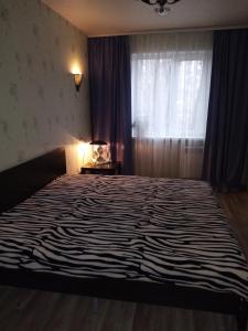 ウリヤノフスクにあるOtradnaya 84 Aquaparkのベッドルーム1室(大型ベッド1台、シマウマの毛布付)