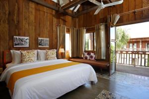 a bedroom with a large bed and a large window at Dontrei Villa Angkor in Siem Reap +140 photos