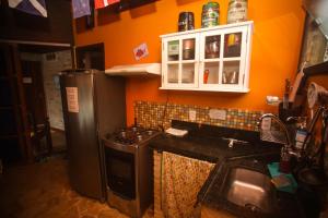 a kitchen with a stove and a refrigerator at Biergarten Hostel in Abraão