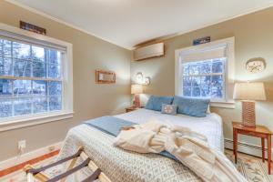 a bedroom with a bed and two windows at Kennebunk Family Cottage in Kennebunk