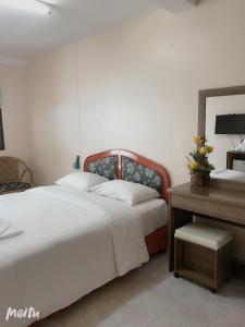 a bedroom with a bed and a desk with a mirror at Baan Boa Guest House in Patong Beach