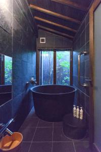La salle de bains est pourvue d'une grande baignoire et d'une fenêtre. dans l'établissement Ayame-an, à Kyoto