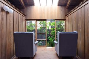 duas cadeiras sentadas num quarto com uma janela em Ayame-an em Quioto