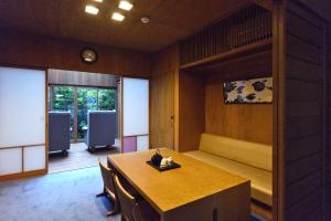 - une chambre avec une table et un banc dans l'établissement Ayame-an, à Kyoto