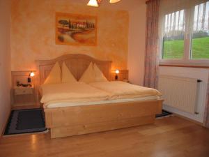 a bedroom with a bed with a wooden headboard and a window at Bauernhof Haim in Pichl bei Aussee