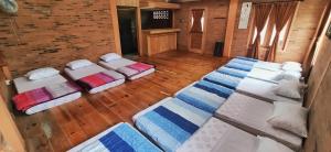a room with three beds and a wooden floor at The Cabin Bungalow in Bedoyo