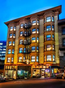 a building on a street with cars parked in front of it at Arundel Mansions Hotel in New Westminster