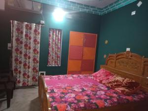 1 dormitorio con 1 cama con sábanas rosas y paredes verdes en Hostel Relax Homestay en Gaya