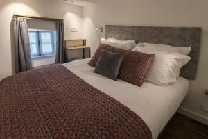 Un pat sau paturi într-o cameră la Eco-Lodge City - Appart'Hôtel - VILLA CÔTÉ PLATEAU - Hyper Centre - 3 Étoiles Certifiées-