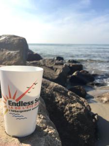 a cup of coffee sitting on the rocks at the beach at Studio 237 Port Camargue, Piscine, Climatisation, 2 personnes in Le Grau-du-Roi