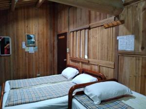 due letti in una stanza con pareti in legno di Chin -Be Village Cafe & Homestay a Beigan