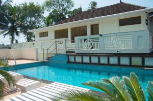 uma casa com piscina em frente a uma casa em Triveny River Palace em Alappuzha