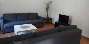 sala de estar con sofá y TV en Puerta de Bisagra- CON 2 HABITACIONES, en Toledo