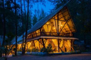 a house with a roof that is lit up at night at The Moken Eco Village - SHA plus in Ko Phra Thong