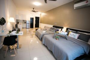 1 Schlafzimmer mit 2 Betten, einem Tisch und einer Küche in der Unterkunft Twin Galaxy Residences By The One in Johor Bahru