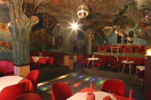 a restaurant with red chairs and a tree mural at Blaue Grotte & Frankenhotel in Debring