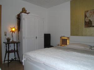 1 dormitorio con 1 cama y 1 lámpara en una mesa en Ferienwohnung Rosentraum en Oberotterbach
