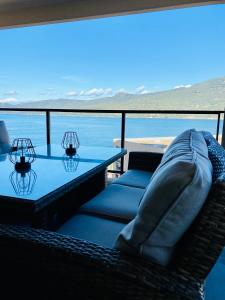 a couch and a table with a view of the ocean at Appartement neuf tout confort en bord de mer in Propriano