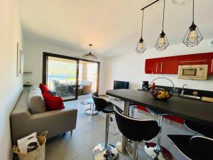 eine Küche und ein Wohnzimmer mit einem Sofa und einem Tisch in der Unterkunft Appartement neuf tout confort en bord de mer in Propriano