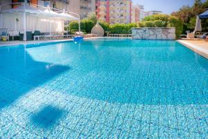a large swimming pool with blue water at Hotel Harry's in Lido di Jesolo