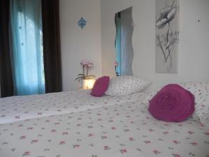 Un dormitorio con una cama con almohadas moradas. en Le Mas du Fort, en Neyron