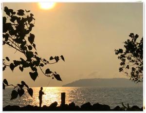 uma pessoa a pescar na praia ao pôr-do-sol em Ta-Lay Time KohMak em Ko Mak