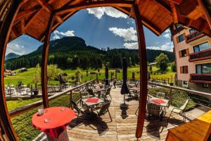 a wooden deck with tables and chairs and a view of a mountain at Cool Studio - Apartment in Gosau - Hallstatt - Wellness and Pool included in Gosau