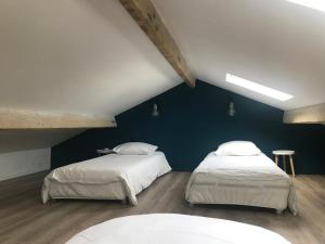 - 2 lits dans une chambre avec un mur bleu dans l'établissement Maison de pêcheur 1900, à Saint-Mandrier-sur-Mer