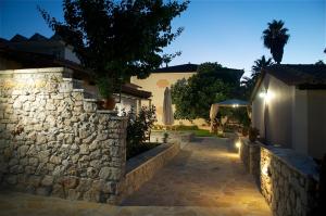 un mur en pierre devant une maison la nuit dans l'établissement Domenica Apts II, à Laganas