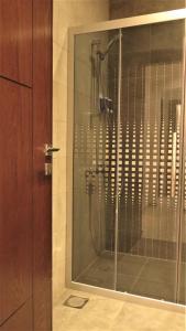 a shower in a bathroom with a glass door at Double Key by HR in Amman