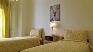 a bedroom with two beds and a table with a lamp at Double Key by HR in Amman