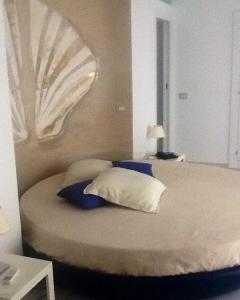 a bed with blue and white pillows in a room at My suite Sorrento in Sorrento
