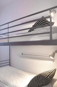 1 dormitorio con litera con barras y estanterías en Woohoo Hostal Madrid, en Madrid