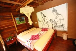 a bedroom with a bed with drawings on the wall at Mount Wood Star in Ella