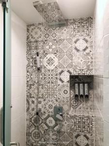 a bathroom with a tile wall with a shower at Stay in Style at Nimman R316 in Chiang Mai