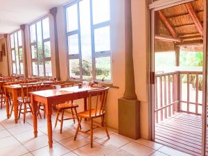 a restaurant with wooden tables and chairs and windows at Selborne Bed and Breakfast in East London