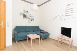salon z niebieską kanapą i stołem w obiekcie Wohnung Waldkauz im Haus Seeadler w Zinnowitz