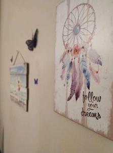 a painting of a dream catcher on a wall with butterflies at Nice and cosy studio in Larisa